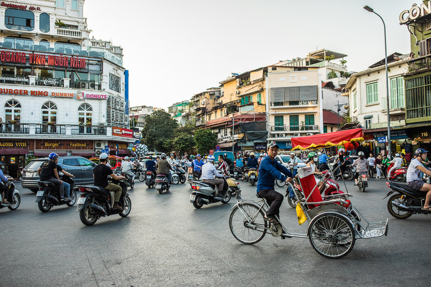 A group of people riding motorcycles and scooters in a busy city

Description automatically generated